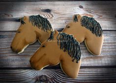 two cookies shaped like horses on top of a wooden table