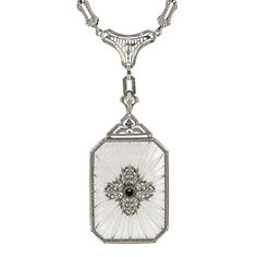 Centering a Round Brilliant cut diamond weighing approx. 0.03ct., on a rectangular sunburst carved rock crystal measuring approx. 30 x 22mm., in an embossed frame, topped and suspended from filigree components, finished by an embossed link chain, fashioned in 14k white gold. Length 16 inches. Luxury Art Deco Filigree Necklace, Luxury Intaglio Jewelry For Evening, Antique Diamond White Pendant Jewelry, White Gold Rectangular Necklace With 17 Jewels, Exquisite Engraved White Jewelry, Exquisite White Filigree Necklaces, Exquisite White Engraved Jewelry, Exquisite White Filigree Necklace, Victorian Engraved Rectangular Necklace