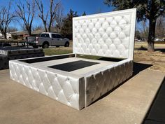 a white bed sitting on top of a cement slab