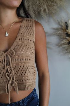 Elevate your wardrobe with our chic crochet vest top, designed for effortless style and comfort. This sleeveless piece features a playful tie-front detail and a flattering plunging V-neckline, adding a touch of sophistication to your look. The delicate crochet pattern adds texture and a hint of bohemian flair, perfect for layering or wearing solo. Ideal for warm weather or a sun-soaked getaway, this vest top effortlessly combines fashion and function. for reference Karlee is 5’8 and wearing a si Tie Crochet Top, Crochet Vest Top, Crochet Bow, Chic Crochet, Delicate Crochet, Square Neck Top, Crochet Vest, Vest Top, Cardigan Jacket