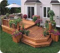 a wooden deck surrounded by potted plants and flowers