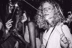 a black and white photo of people at a party with sparklers in the air