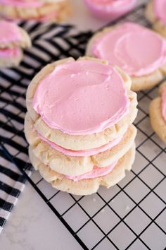 cookies with pink frosting sitting on a cooling rack