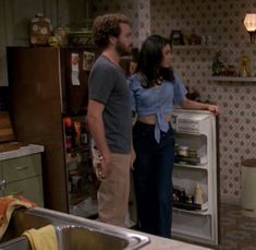 two people standing in front of an open refrigerator