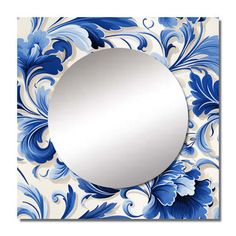 a blue and white flowered wall mirror with a circular mirror in the middle on top of it