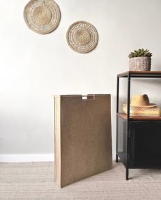 two baskets are hanging on the wall next to a shelf