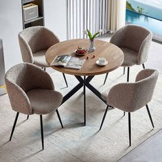 a table with four chairs around it and a magazine in front of it on the floor