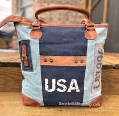 Blue two tone tote canvas and leather bag crafted of repurposed and upcycled sustainable Military Canvas into this great purse or tote bag. Plenty of room for everything you need. Convenient front pocket and adjustable crossbody strap make it the perfect bag to show your pride with ease, d comfort and style! A perfect gift for all those patriotic peeps, military moms, wives and all that just love a quality bag. 17" x 14.5" x 4" <<-- Please Check the DIMs! Fully Lined Inside Zip top Closure Leath Vintage Blue Bags With Leather Handles, Vintage Blue Bag With Leather Handles, Vintage Blue Shoulder Bag With Leather Handles, Casual Canvas Bags With Upcycled Details, Vintage Canvas Shoulder Bag For Errands, Casual Upcycled Canvas Shoulder Bag, Upcycled Tote Shoulder Bag For Everyday, Upcycled Everyday Tote Shoulder Bag, Upcycled Satchel Bag For Everyday Use