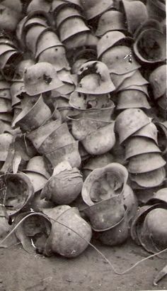 an old black and white photo with many hats stacked on top of eachother