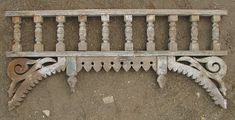 an old wooden bench sitting on top of a dirt ground next to a wall and fence