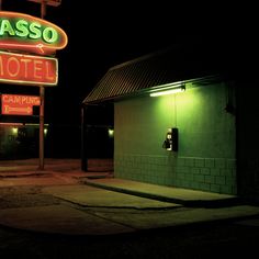 a neon sign that is on the side of a building in front of a motel