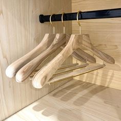 three wooden hangers are hanging on the wall