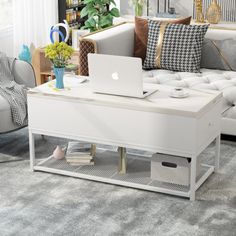 a living room filled with furniture and a laptop computer on top of a coffee table