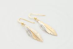 Striking gold and sterling silver feather simple earrings, a perfect treat for yourself or gift for someone special. The gold feather measures 30m x 6mm and the silver feather is 15mm x 4mm. These gorgeous feather earrings are great for everyday wear and also look stunning in the evening too. They are also great for bridesmaids and a gift that they would wear again and again. They come in a box with ribbon perfect for gifting. They are also available in sterling silver. Gold Feather Jewelry For Wedding, Gold Feathered Wedding Jewelry, Elegant Feather Jewelry Gift, Elegant Feather Jewelry As Gift, Elegant Feather Jewelry For Gift, Elegant Feather Dangle Earrings, Elegant Dangle Feather Earrings, Elegant Dangle Earrings With Feathers, Elegant Feather Dangle Jewelry