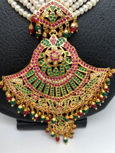 Red Green Stone Pendent Traditional Raani Haar with Real Pearls with matching earringsColor : Golden, Pearl WhiteSize : Necklace Length : Approx 22 Inches; Earring Length 2.5 Inches; Pendent Length 5 InchesStones : Red Green Stone AD and Pearls Traditional Green Pearl Necklace For Festive Occasions, Traditional Green Pearl Earrings, Traditional Green Pearl Necklace With Meenakari, Traditional Green Jewelry With Pearl Pendant, Luxury Traditional Green Pearl Necklace, Traditional Necklace, Golden Pearl, Real Pearls, Green Stone