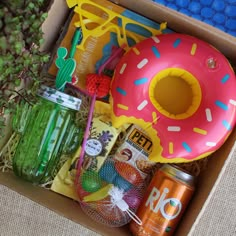 a box filled with assorted items such as an inflatable donut, soda and candy