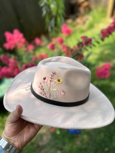 Hand embroidered felt mixed polyester wide brim hats with 2 color options which are cream and black. They are one size and have adjustable ribbons in it. Cream has leather and chain belt around it. Black has a leather ribbon around it. Note: Embroidery is stitched only on the right side of the hat. It doesn't fully wrap around the crown. Cream hat size crown is 7 inches, total with brim 15 inches. Black hat size crown is 7 inches, total with brim 13 inches. Do not wash. Spot clean if needed. Trendy Short Brim Felt Hat For Festivals, Spring Felt Hat With Curved Brim, Trendy Curved Brim Felt Hat For Festivals, Trendy Curved Brim Felt Hat For Rodeo, Trendy Felt Hat With Curved Brim For Rodeo, Trendy Wide Brim Felt Hat For Festivals, Beige Flat Brim Felt Hat For Spring, Trendy Brimmed Felt Hat For Country Events, Cream Felt Hat With Flat Brim For Spring