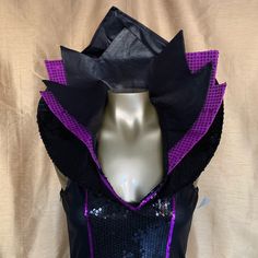 a mannequin wearing a purple and black top with sequins on it