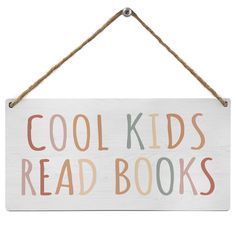 a sign that says cool kids read books hanging from a rope on a white wall