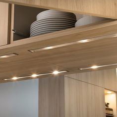 the lights are on in this kitchen under the cabinetry and above the countertop