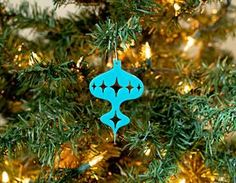 a blue ornament hanging from the top of a christmas tree