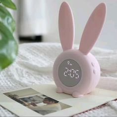 a pink alarm clock sitting on top of a bed