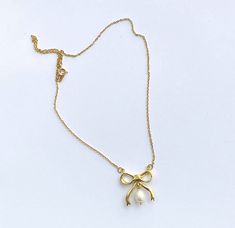 "beautiful Bow Necklace with Freshwater Pearl drop perfect for any occasion. Carved in wax then cast in metal and dipped in a thick layer of 18CT Gold. Hangs on an 18\" gold plated chain. All pieces are handmade to order by UK designer Rebecca Gladstone.  Handmade to order please allow 2-3 weeks for delivery. Your necklace will arrive housed in an embossed gift box. Necklace also available in Sterling Silver option.  Material Composition: Brass/18CT Gold Plating Sterling Silver 925 Freshwater Pearls" Gold Pendant Pearl Necklace For Party, Gold Pearl Pendant Necklace For Party, Gold Charm Necklaces For Parties, Gold Plated Teardrop Pendant Chain Necklace As Gift, Gold Brass Necklace With Pearl Chain, Party Gold Chain Necklace With Pearl Pendant, Gold Chain Necklace With Pearl Pendant For Party, Gold Teardrop Charm Necklaces For Jewelry Making, Teardrop Pearl Necklace Clavicle Chain Gift