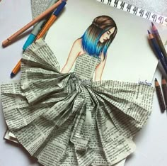 an image of a woman's dress made out of newspaper paper and pencils