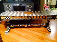 a table that has some sort of checkered design on it, sitting on a hard wood floor