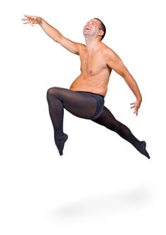 a shirtless man is jumping in the air with his arms out and legs spread wide