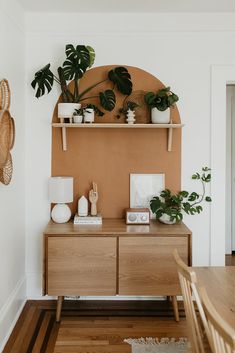 a wooden table topped with potted plants next to a wall mounted shelf