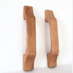 two wooden door handles on a white wall