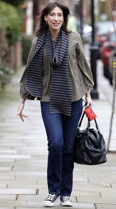 a woman walking down the street carrying a handbag