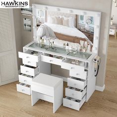 a white vanity with drawers and a mirror on the wall next to it is a bed