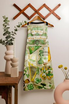 a st patrick's day dress hanging on a wall next to a potted plant