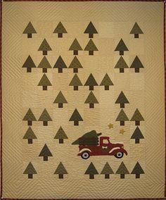 a quilted wall hanging with trees and a red truck in the middle on it