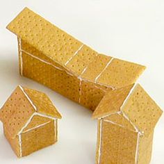 three small houses made out of paper on a white surface