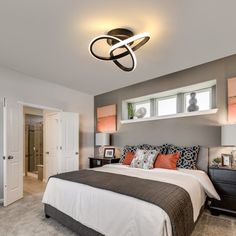 a bedroom with a bed, nightstands and two lamps on the wall above it