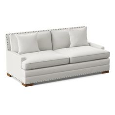 a white couch with four pillows on the back and one arm folded up to it's side