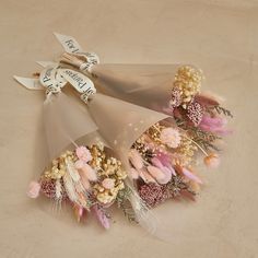 an arrangement of dried flowers and ribbons on a beige tablecloth with a ribbon that says happy new year