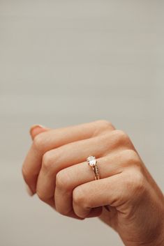 a woman's hand with a diamond ring on her finger, holding it in the air