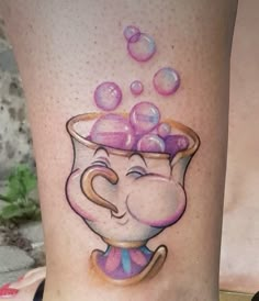 a woman's leg with an elephant in a cup tattoo on her thigh, and bubbles coming out of it