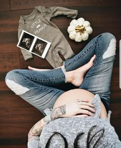 a pregnant woman laying on top of a wooden floor