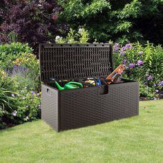 an outdoor storage box in the middle of a garden filled with gardening tools and supplies