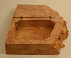 a wooden box sitting on top of a white wall next to a tree stump trunk