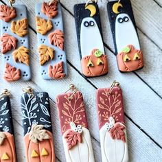 decorated cookies are arranged in rows on a wooden table with fall leaves and pumpkins