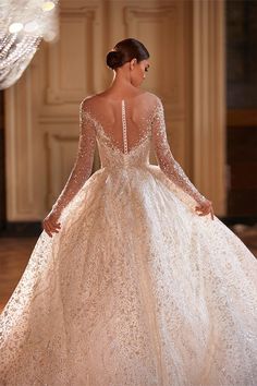 the back of a wedding dress with long sleeves and an intricate lace pattern on it