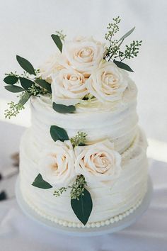 a wedding cake with white flowers and greenery