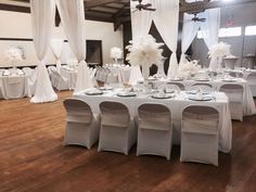 the tables are set with white linens and centerpieces