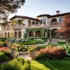 a large house with lots of flowers in the front yard